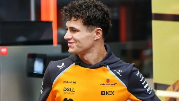 Lando Norris mengenakan seragam tim McLaren berwarna oranye dan hitam sambil menoleh ke samping